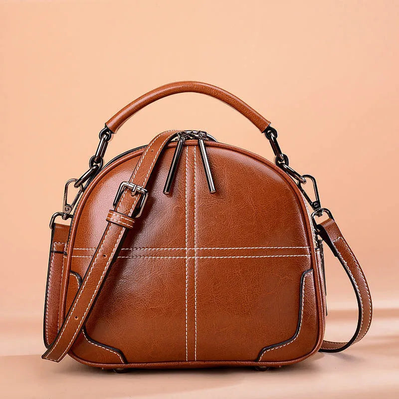 Round two-layer cowhide leather handbag with zipper closure available in wine red black and brown