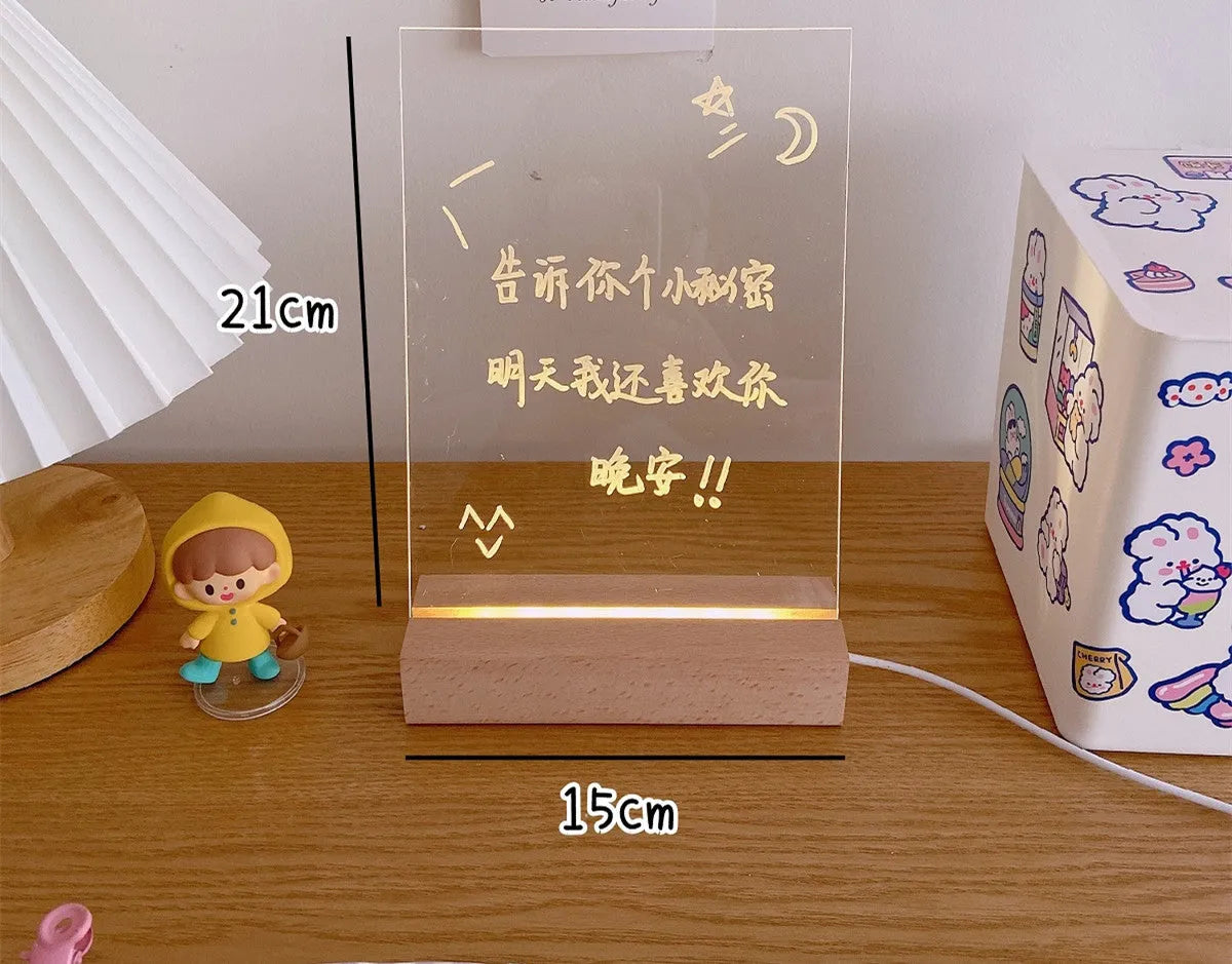 White decorative LED bedside night light with a writable message board on a wooden nightstand.