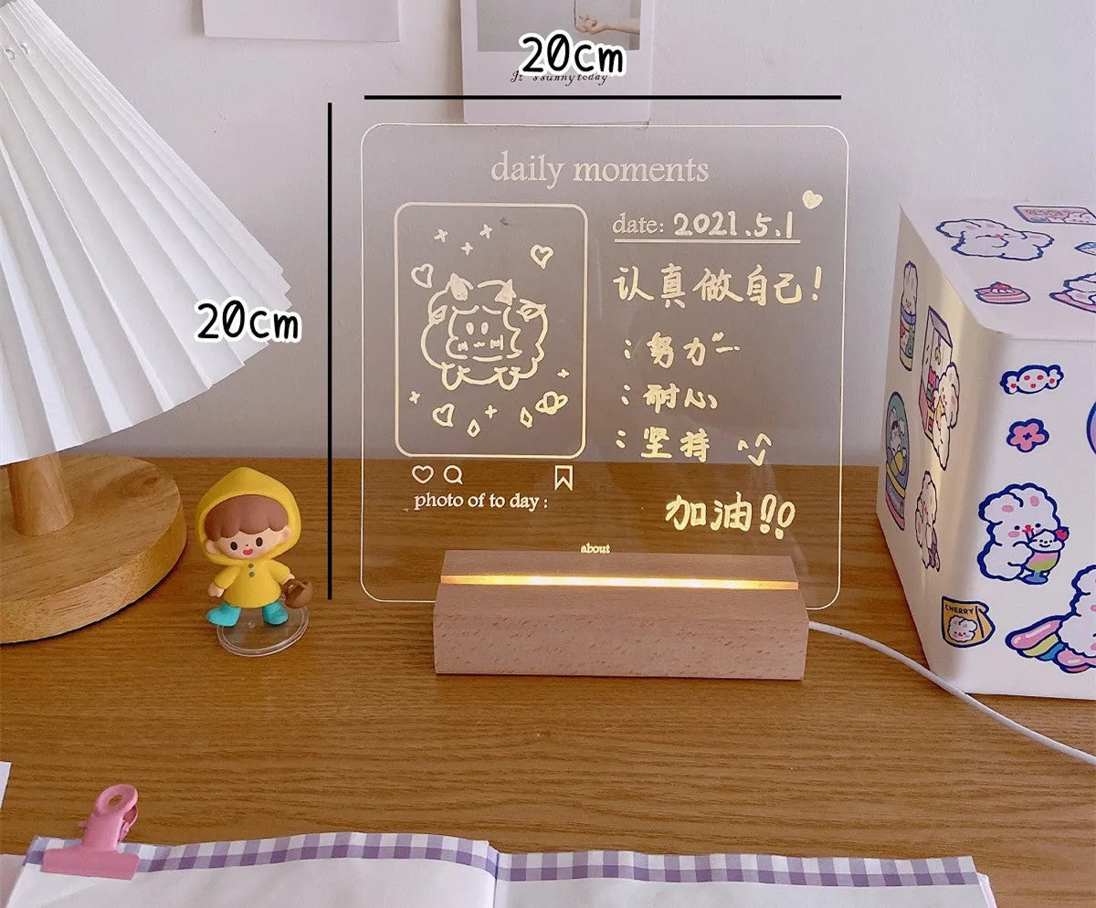 White decorative LED bedside night light with a writable message board on a wooden nightstand.