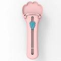 Green and pink handheld pet food squeezer spoon feeder for cats and dogs.