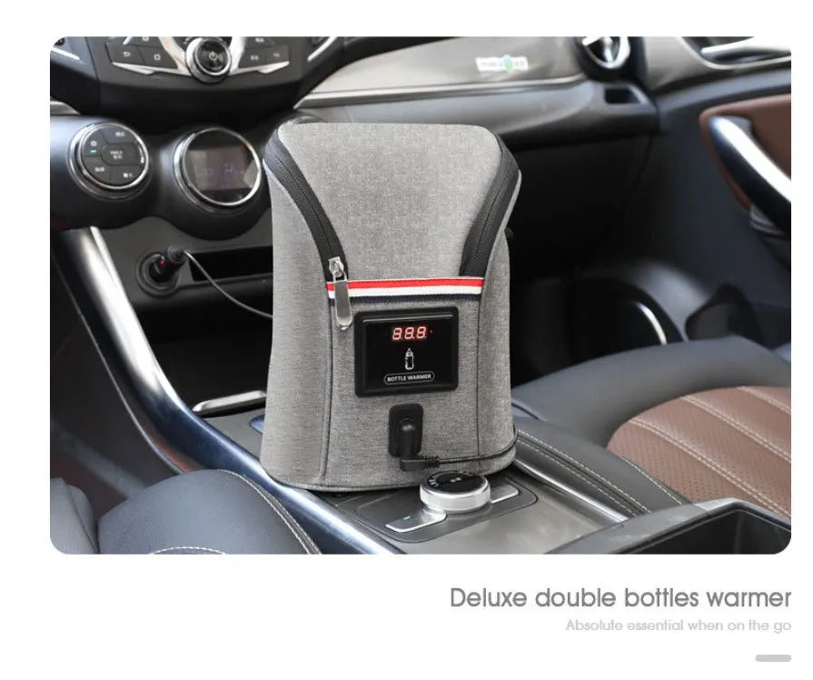 Grey portable car baby bottle warmer with dual slots and digital temperature display screen connected to 12V charger