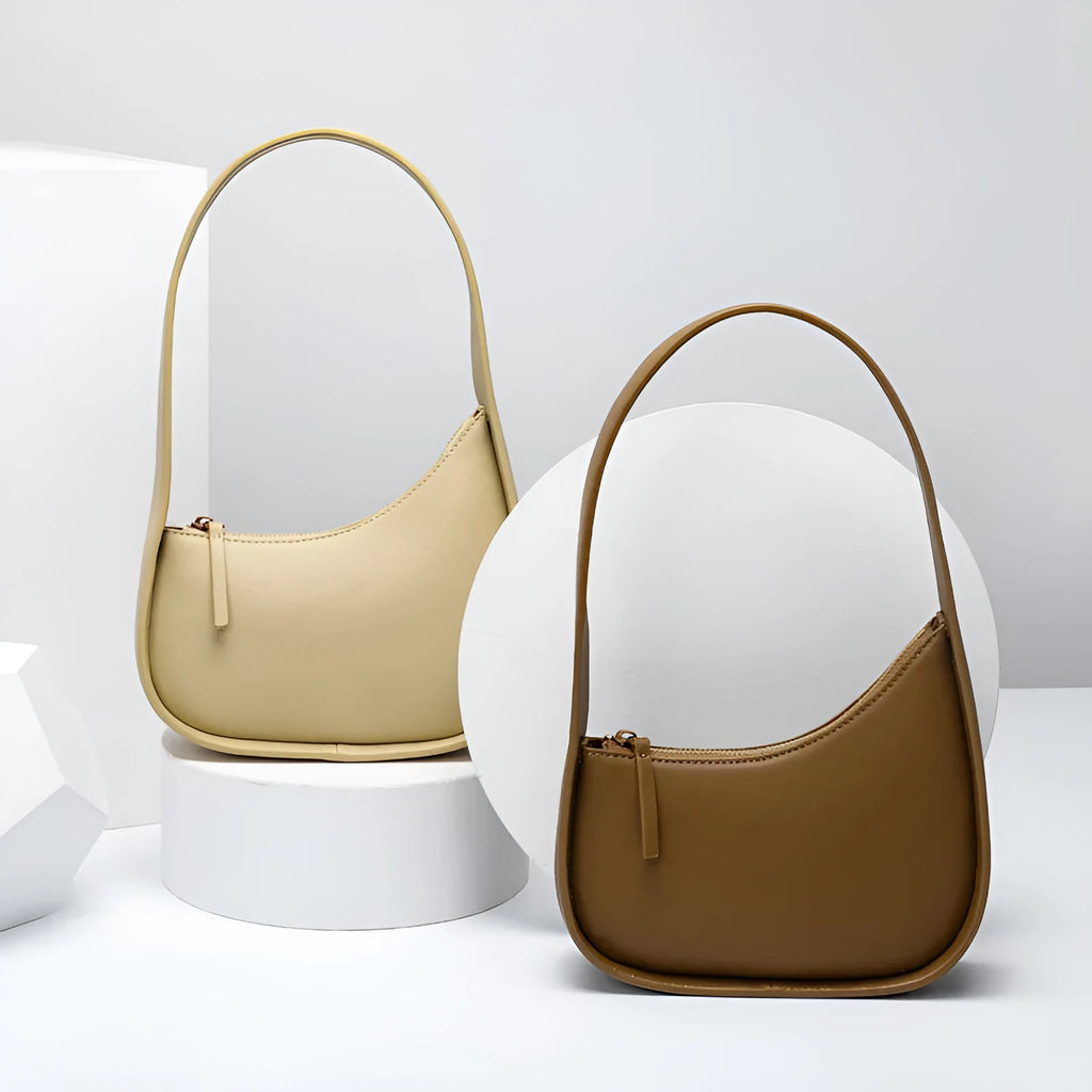 Small genuine cowhide leather half moon handbag with a wide shoulder strap.