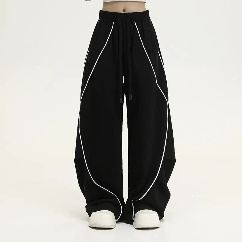 Black striped pleated hip hop trousers with wide-leg design shown flat