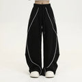 Black striped pleated hip hop trousers with wide-leg design shown flat