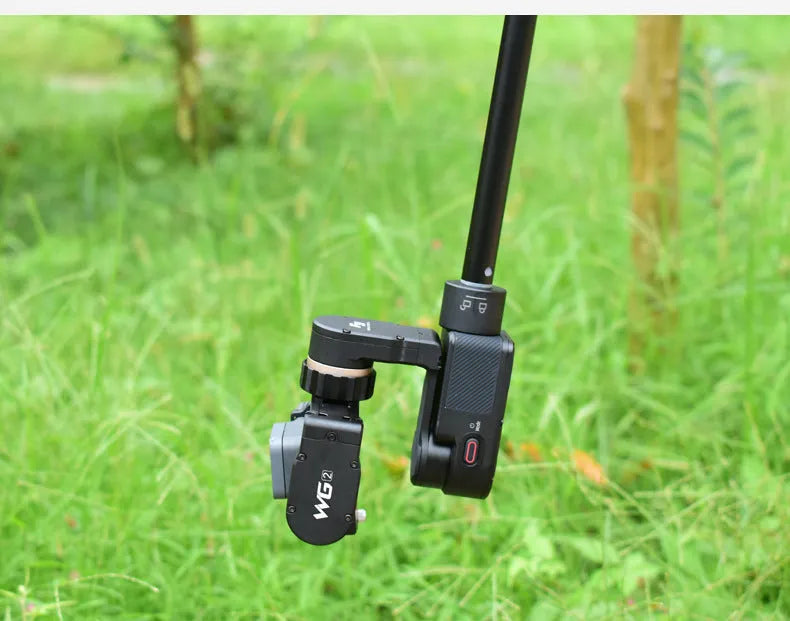 Black retractable aluminium selfie stick with hand-held stabiliser grip holding a smartphone.