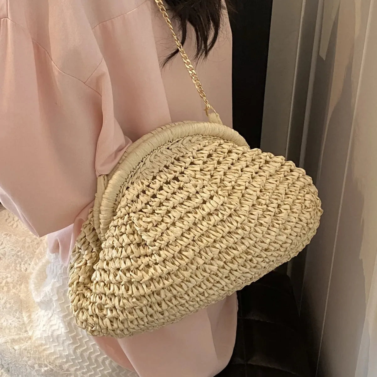 Khaki shell-shaped straw shoulder bag for women with chain detail and an internal zipper pocket.