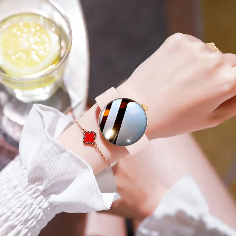 Circular women's smartwatch with metal strap and colour touchscreen display on a wrist.