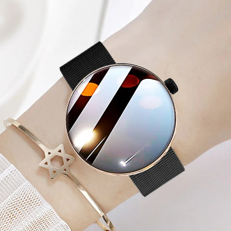 Circular women's smartwatch with metal strap and colour touchscreen display on a wrist.