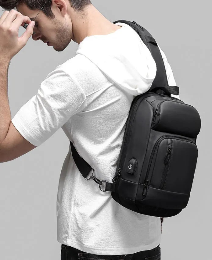 Black medium PVC outdoor shoulder bag showing air cushion strap, soft handle, and internal organiser pockets.