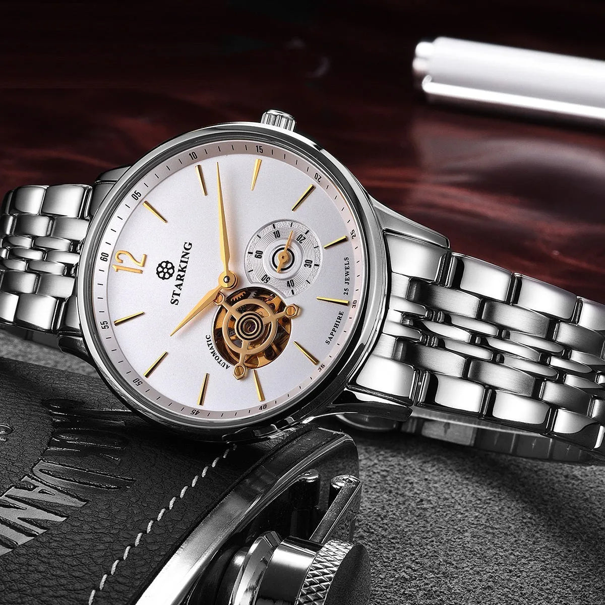 Men's steel and brown leather automatic business watch with hollow dial on white background