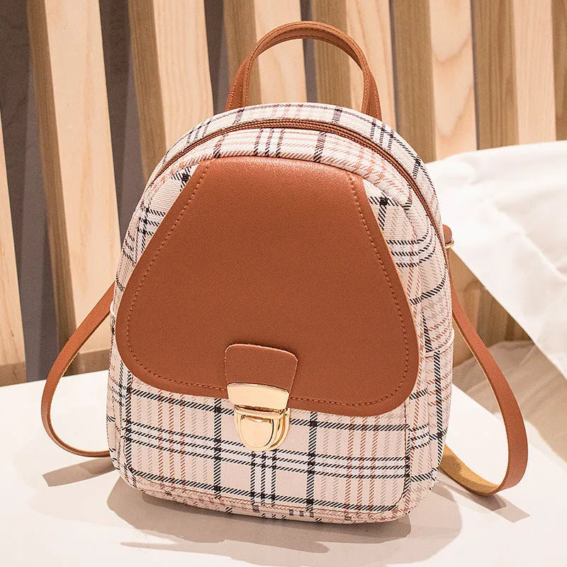 A black diagonal one-shoulder phone bag made from PU fabric, shown being carried by hand.