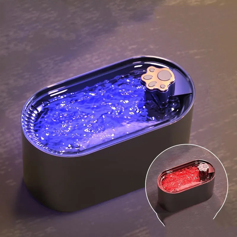 Blue automatic pet water fountain with filter on a floor next to a cat