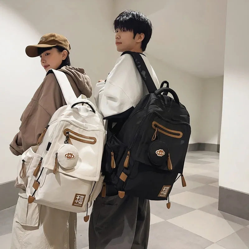 Large black nylon backpack for middle school students with curved shoulder straps and street style sewing details