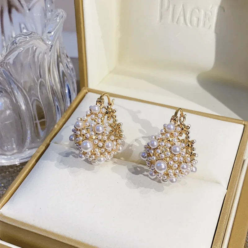 Women's gold flower basket earrings with small beads and pearl inlay detailing on copper