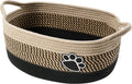 Light beige handmade woven cotton rope storage basket with wooden handle on a table.