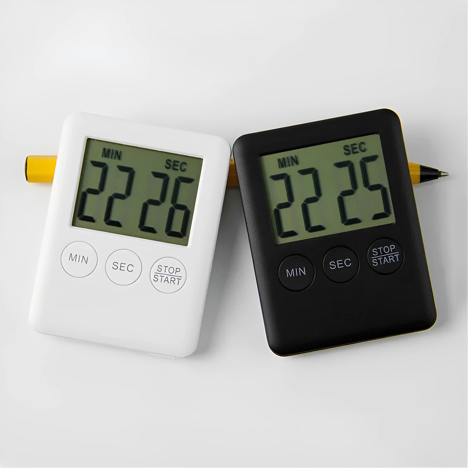 Black and white kitchen timer with magnet back for refrigerator mounting.