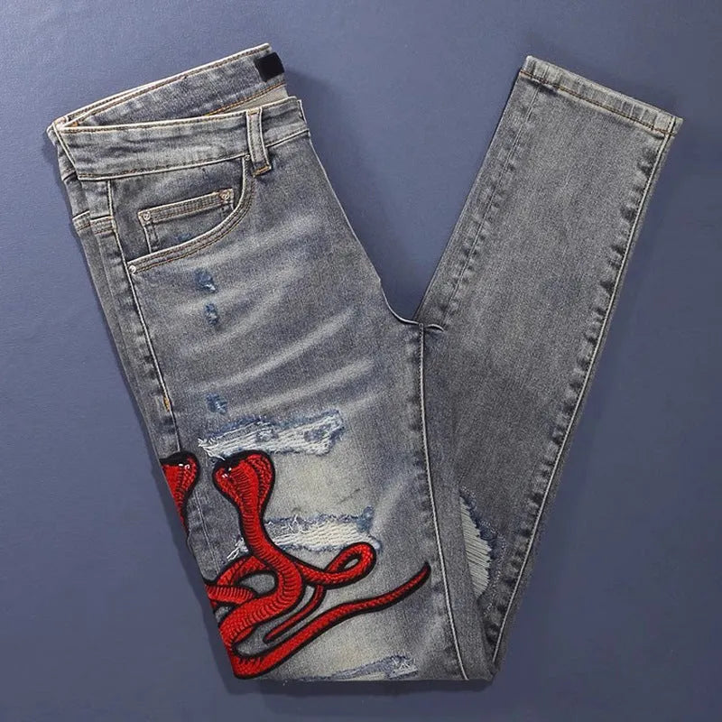 Men's slim fit jeans in a washed-out old colour with distressed hole and patch details on the legs.