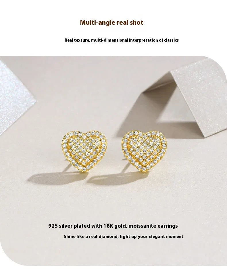 A pair of gold-coloured heart-shaped moissanite stud earrings on S925 silver posts.