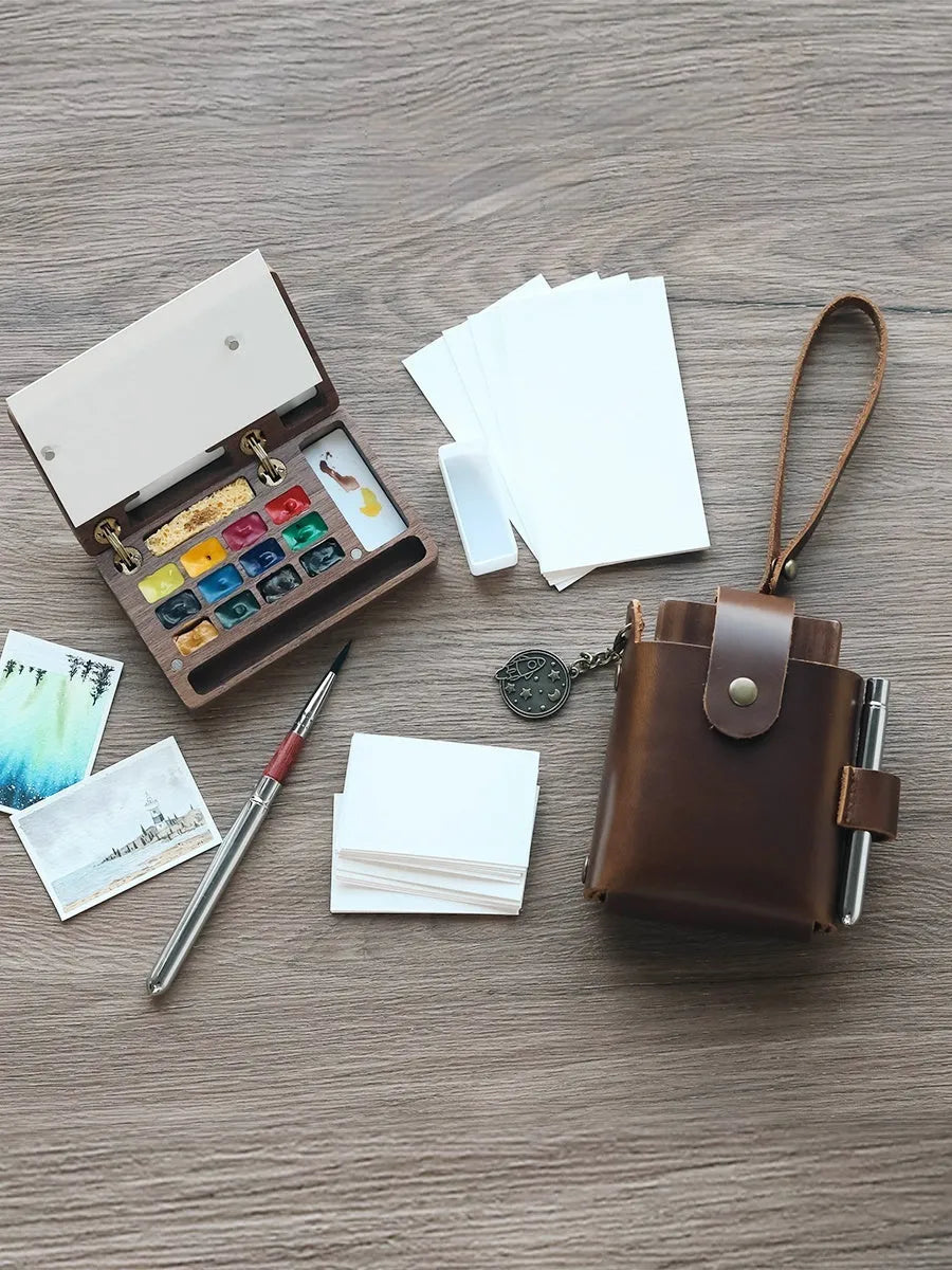 Mini walnut wood watercolour paint box open to show pigment suit selection