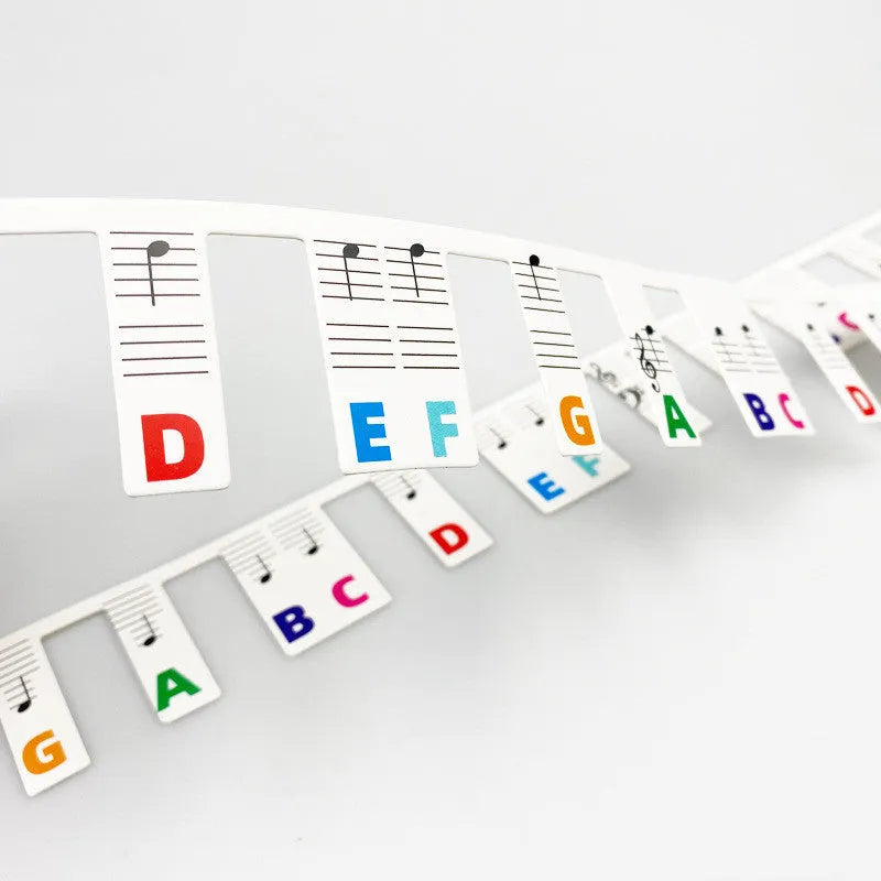 White card piano note bar stickers for 88-key keyboards with colour-coded notes and separate black note bag