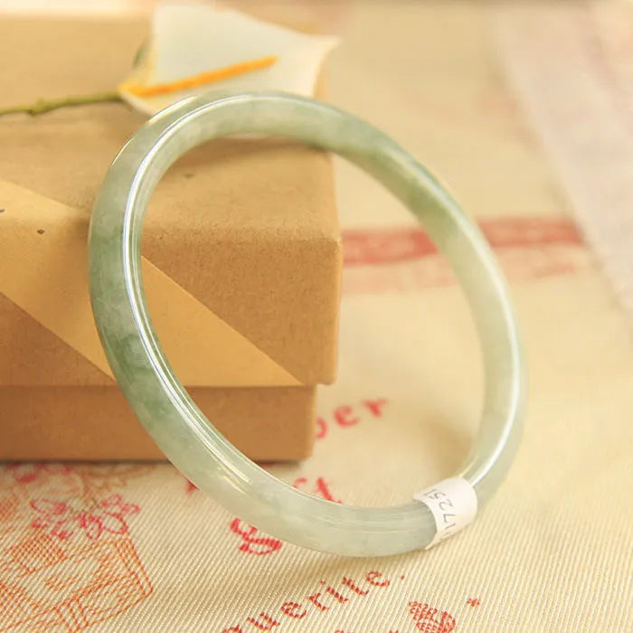 Green geometric Chinese style jade waxy bracelet shown on a wrist, highlighting its 10mm width and detailed pattern.