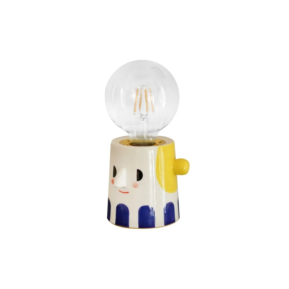 Handmade ceramic bedside lamp with ball-shaped headlight design on wooden surface