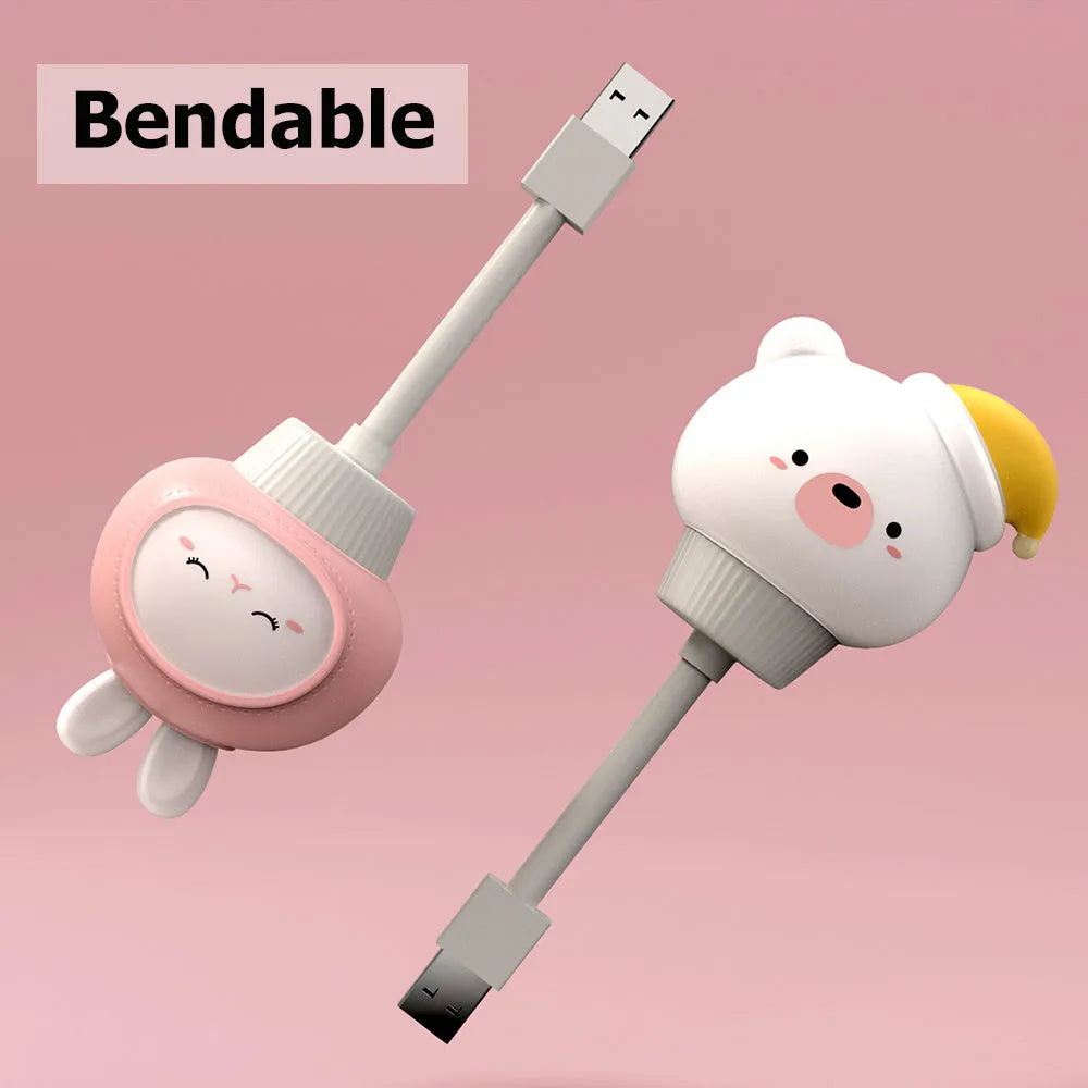 White cartoon bear-shaped USB night light with remote control on a wooden table.