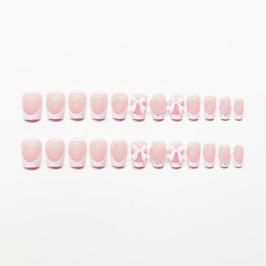 Artificial fashion nail set with white French tips, bow designs, and multiple patterns including tulip and starry sky