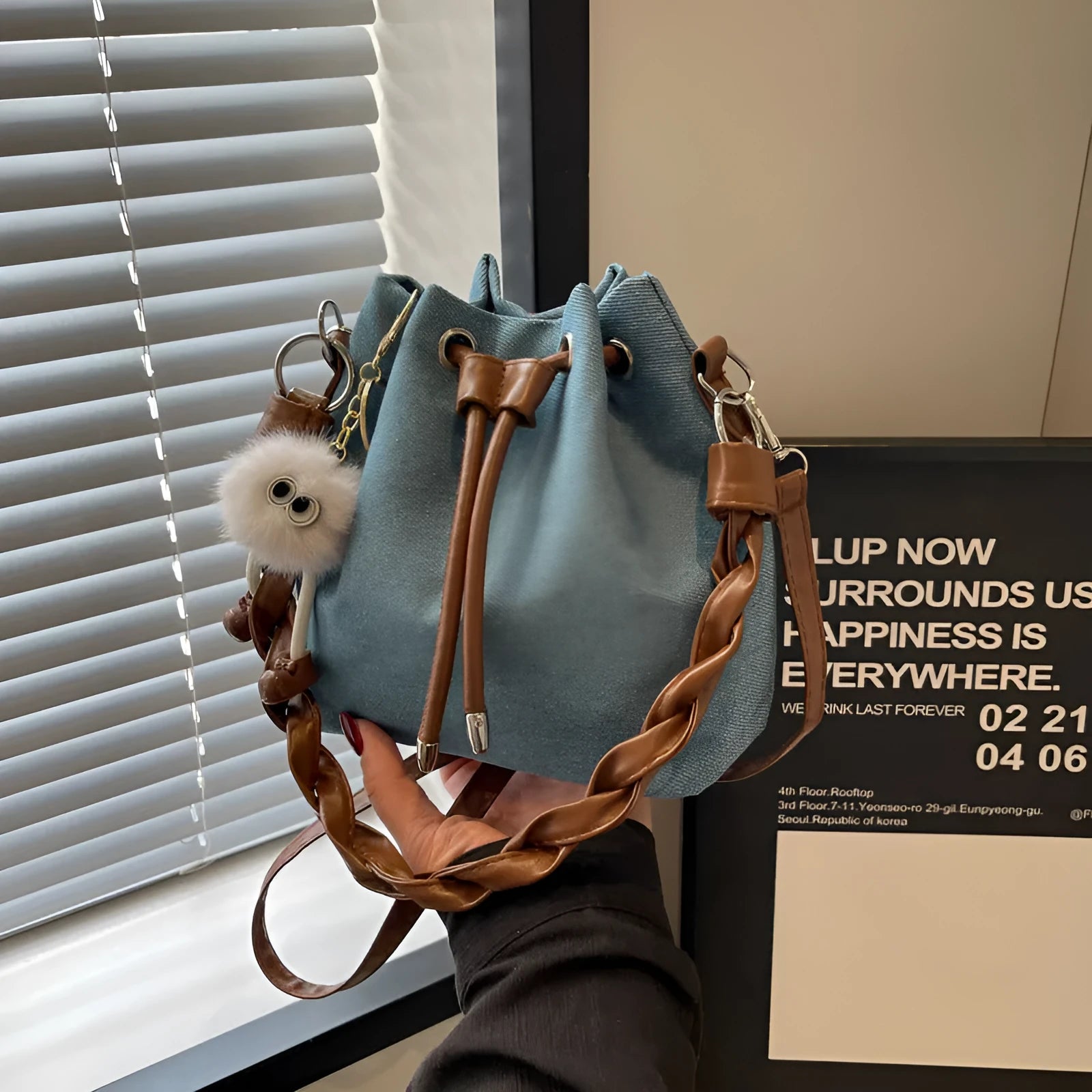Blue one-shoulder cross body bucket bag with synthetic leather lining and medium-soft construction