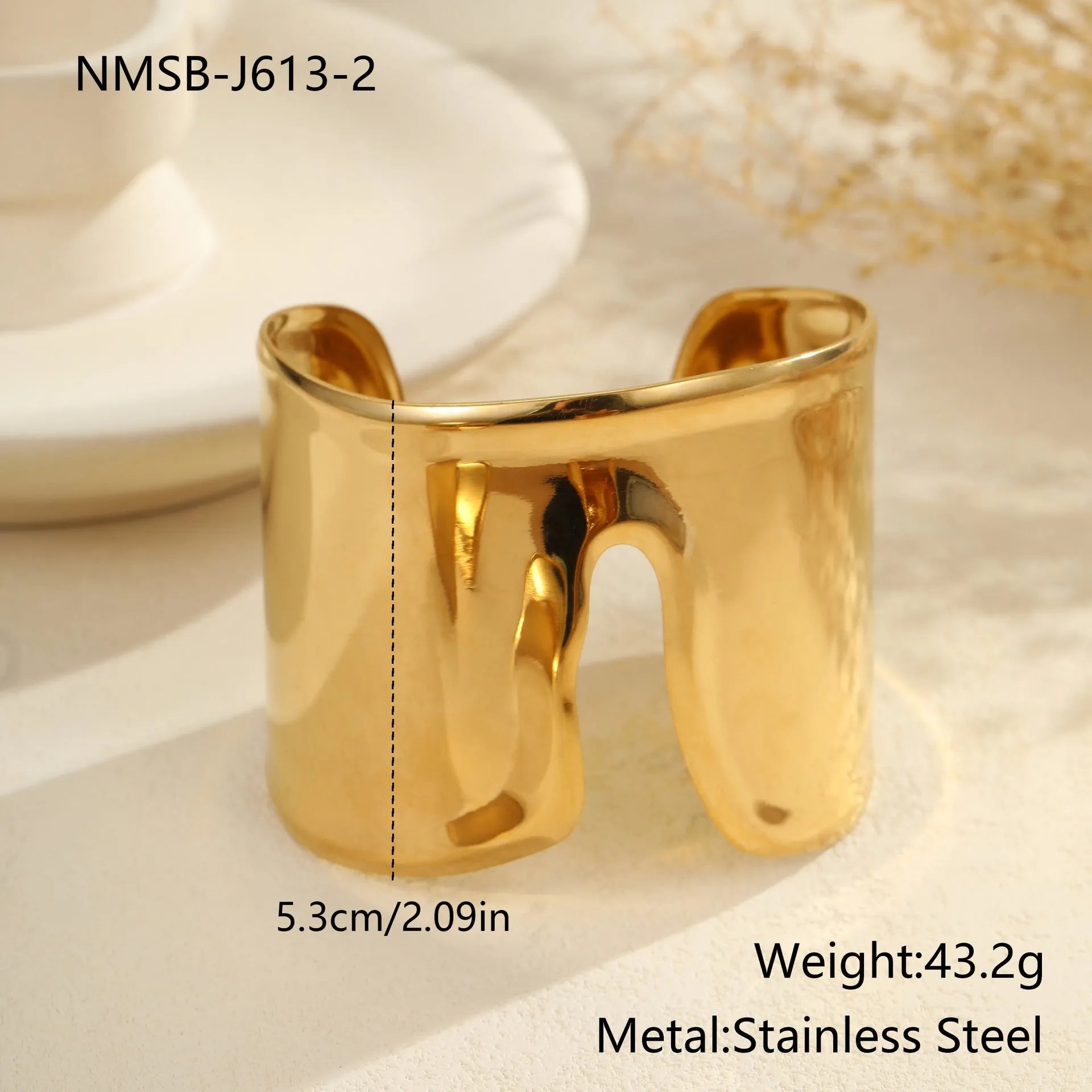 Women's wide stainless steel bracelet with gold plating and wave geometric pattern