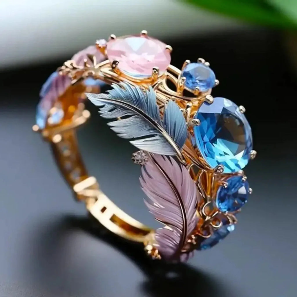 Geometric gold-coloured brass ring with embossed feather pattern and zircon stone inlay.