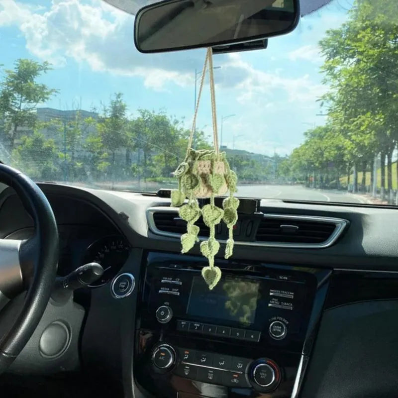 Green and white hand-knitted car plant ornament with a hanging cord on a basin-shaped base.