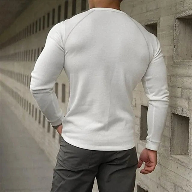 Man wearing a navy blue long-sleeved t-shirt with a henry collar, showcasing the European cut and cotton blend fabric.