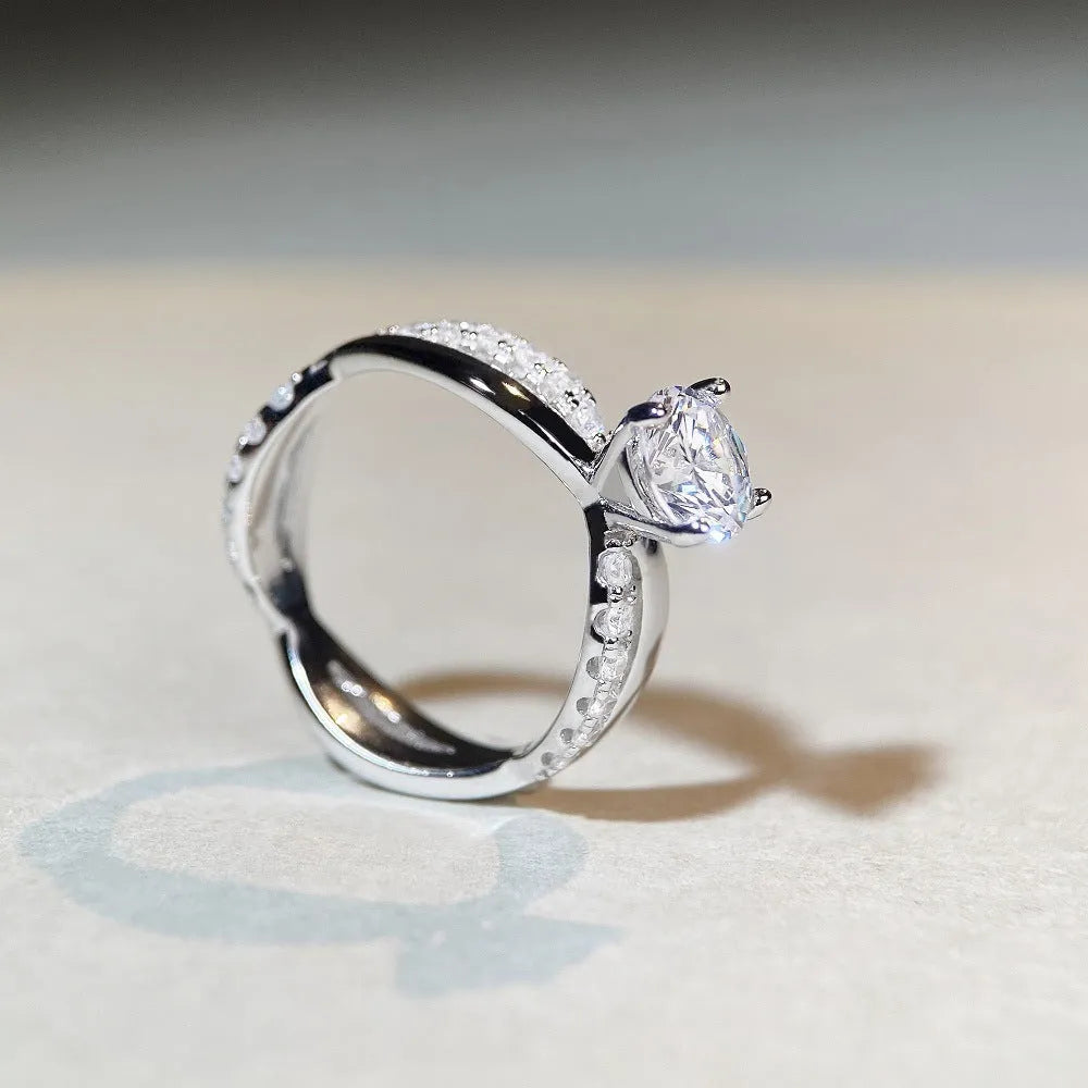 Silver geometric cross ring with a 1 karat moissanite stone and twisted band.