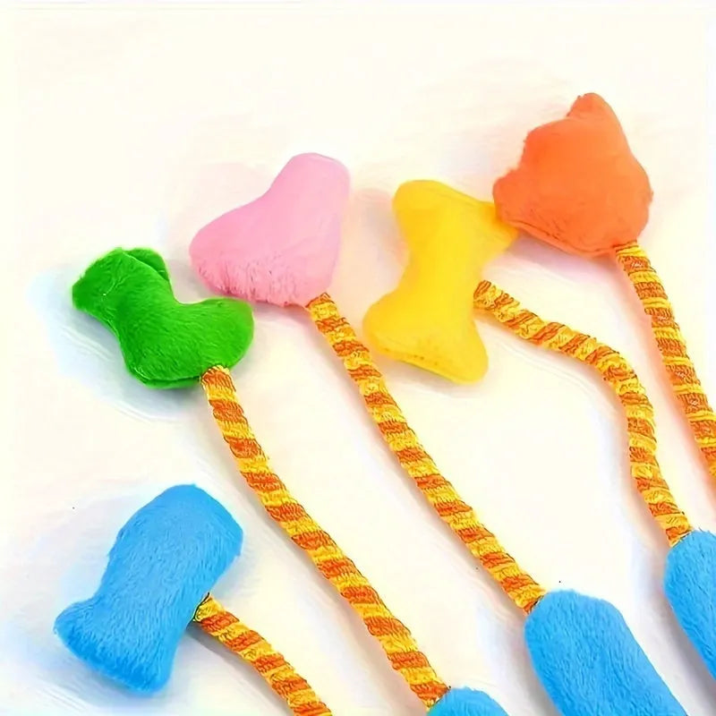 Yellow and blue plush cat toy with magic glove attachment and integrated bell, shown next to measurement scale