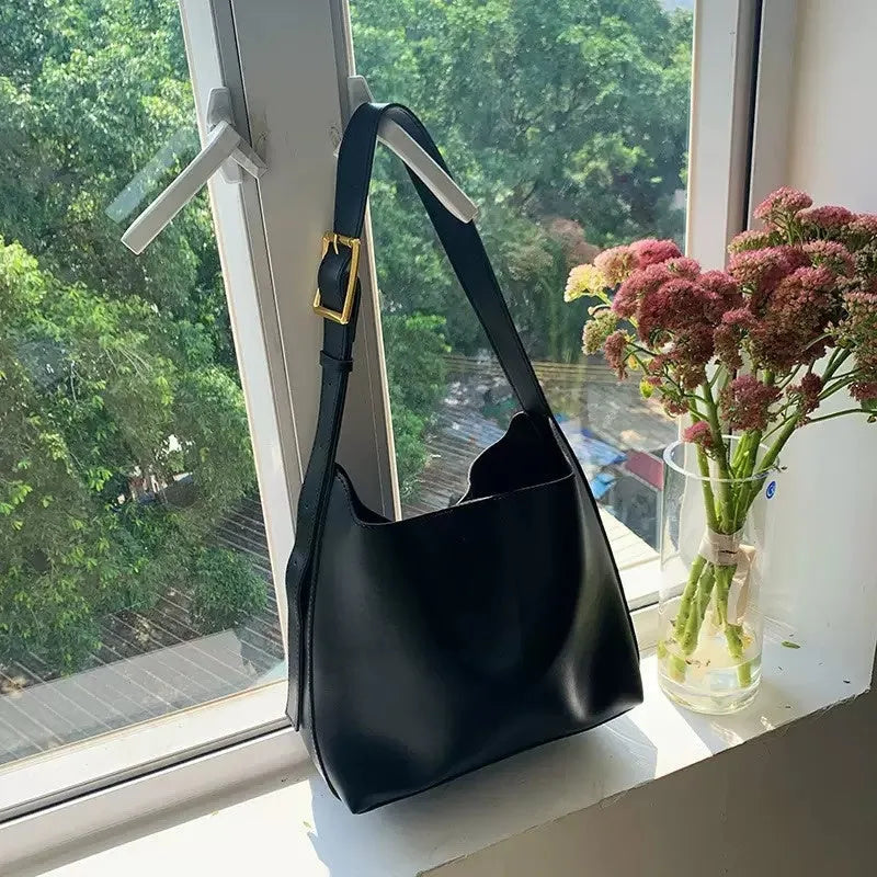 Two women's fashion shoulder bags: black with ribbon and brown with packet designs showing swing thread details