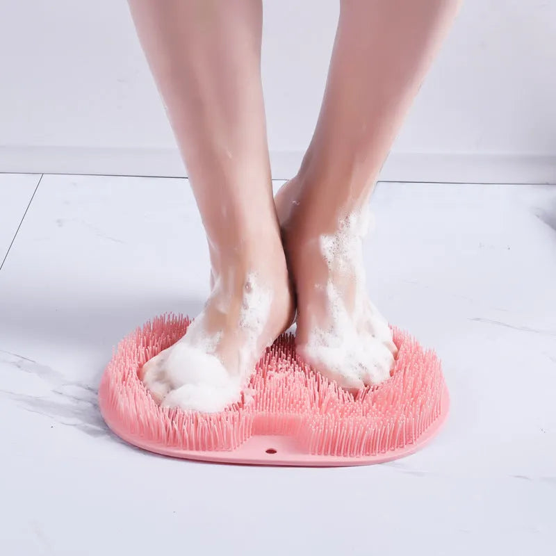 Orange non-slip silicone bath massage mat with suction cups on a bathroom floor.