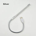 Spiral-shaped aluminium USB desk lamp in black on a wooden desk