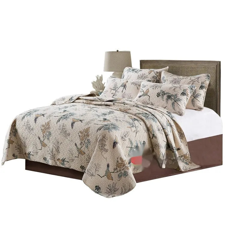 Quilted cotton bed cover set with printed pattern on bed with matching pillowcases