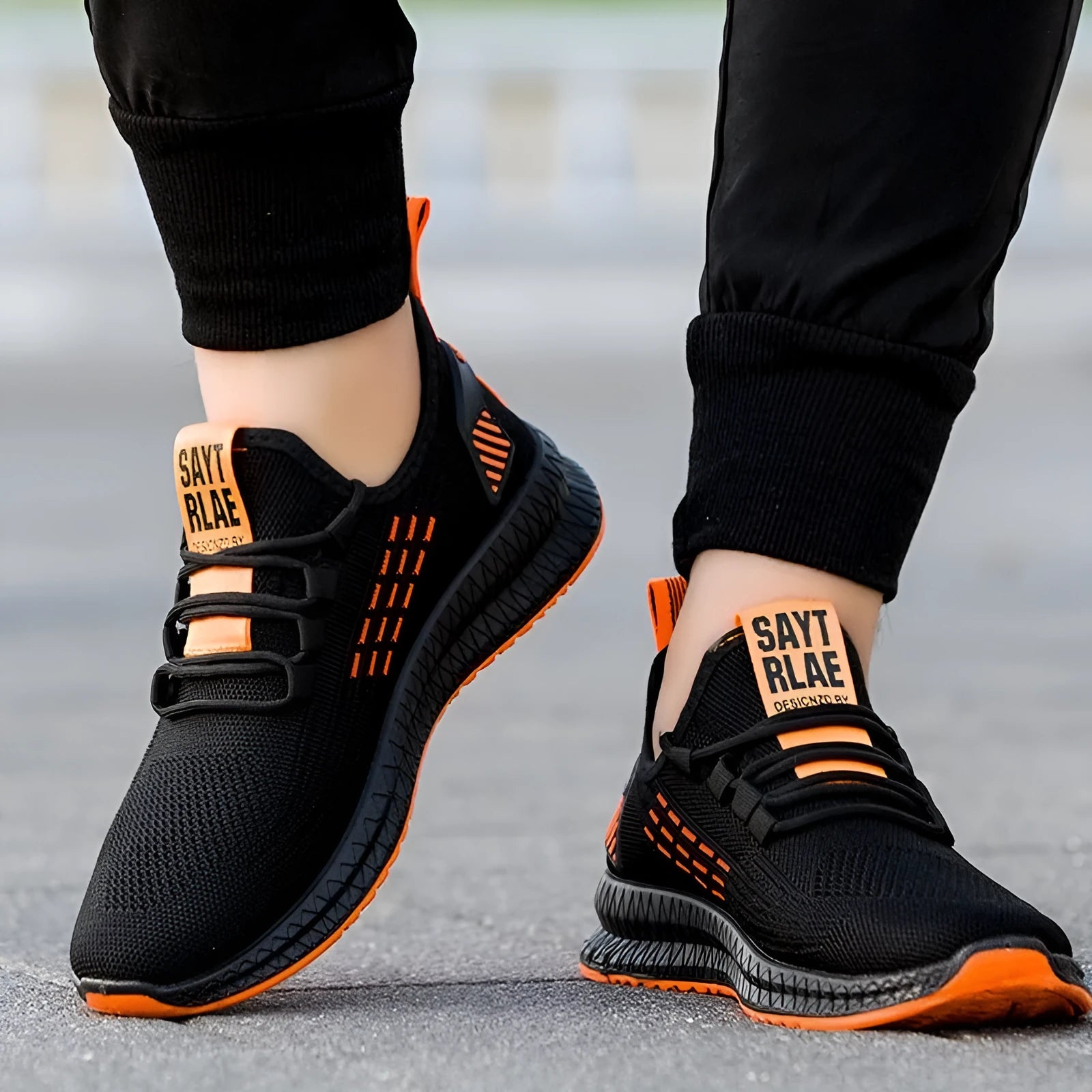 Men's black low-top casual sports shoes with cross strap design on a Flying Weave upper.
