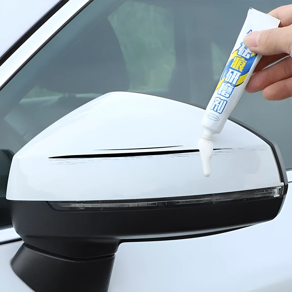 Automotive scratch repair kit with paint pen, wax tube, sponge, and sandpaper for DIY car paint touch-up.