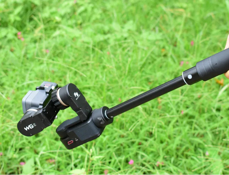 Black retractable aluminium selfie stick with hand-held stabiliser grip holding a smartphone.