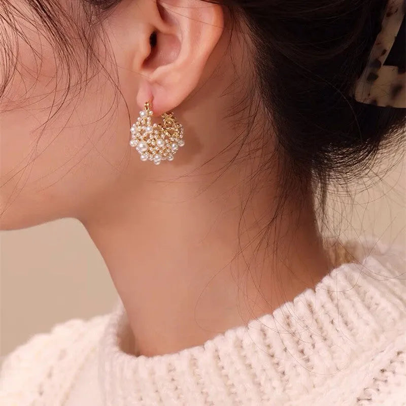 Women's gold flower basket earrings with small beads and pearl inlay detailing on copper