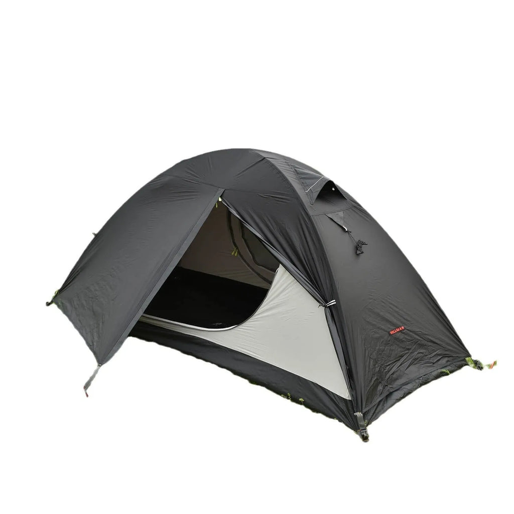 Red single person dome tent with aluminium poles pitched outdoors, showing double-layer construction.