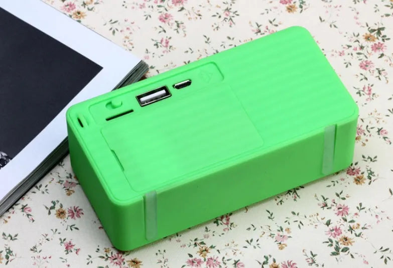 Cannon X3 small cube-shaped portable Bluetooth speaker with FM radio, shown in available colours: black, blue, green, red, yellow.