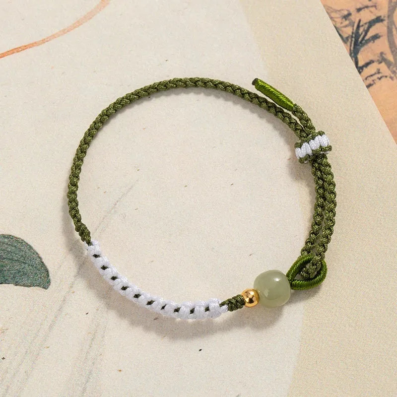 Women's Chinese national bracelet with Hetian jade charm on cord carrying strap