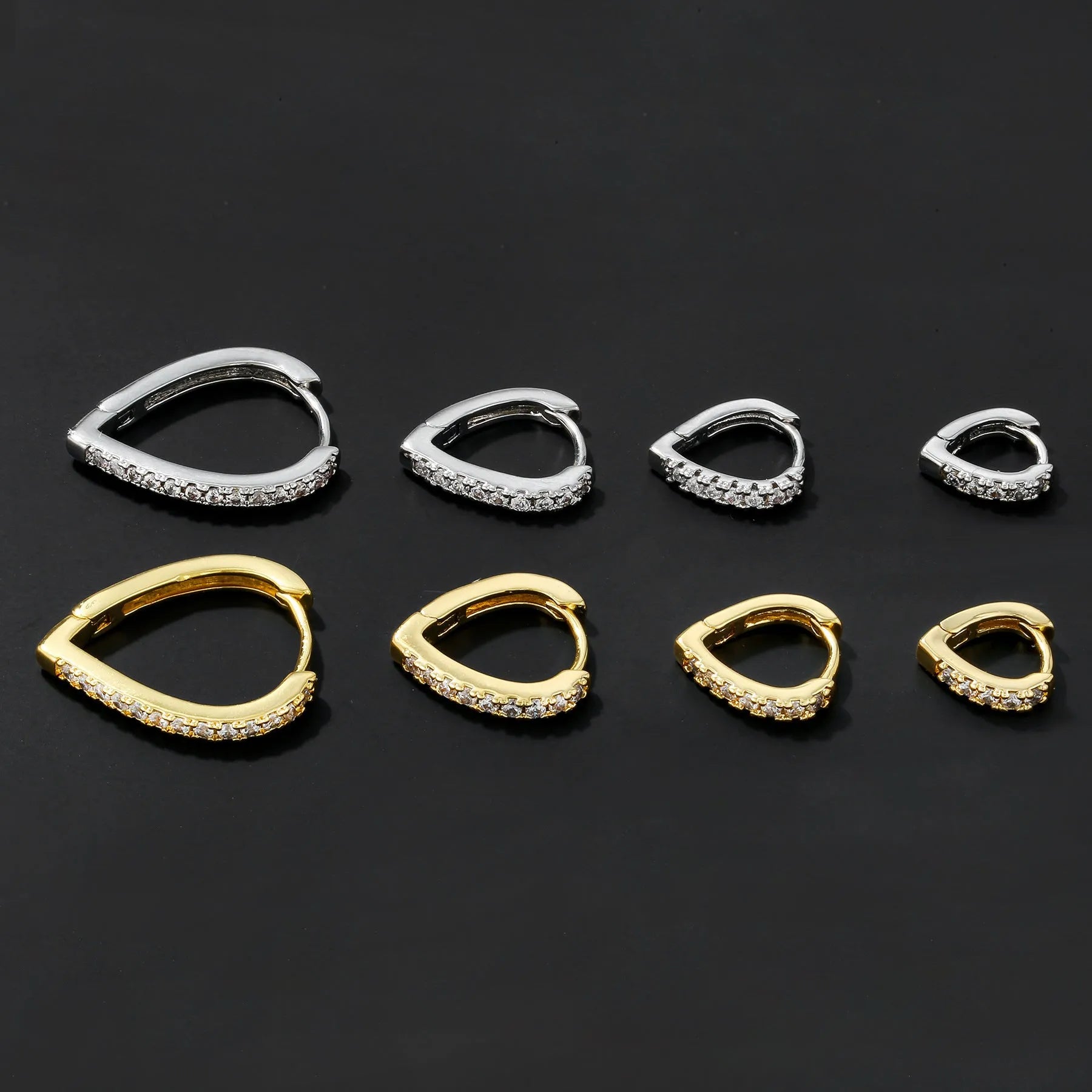 A geometric heart-shaped copper ear clip with a gold or white electroplated finish.