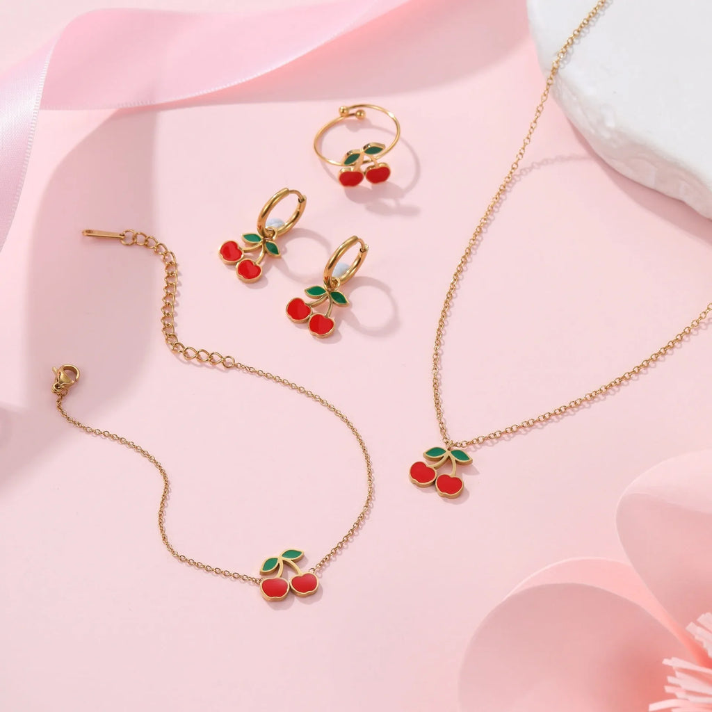 Cherry charm jewellery set showing necklace, bracelet, earrings, and ring in 18K gold plated stainless steel