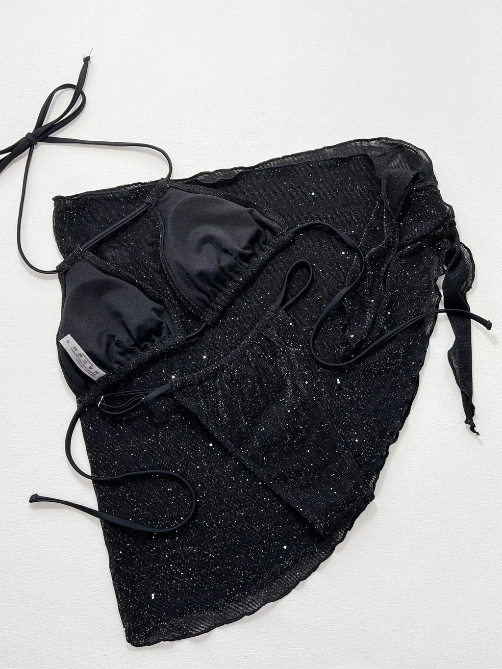 Black three-piece bikini swimsuit set with a top and shorts on a mannequin.