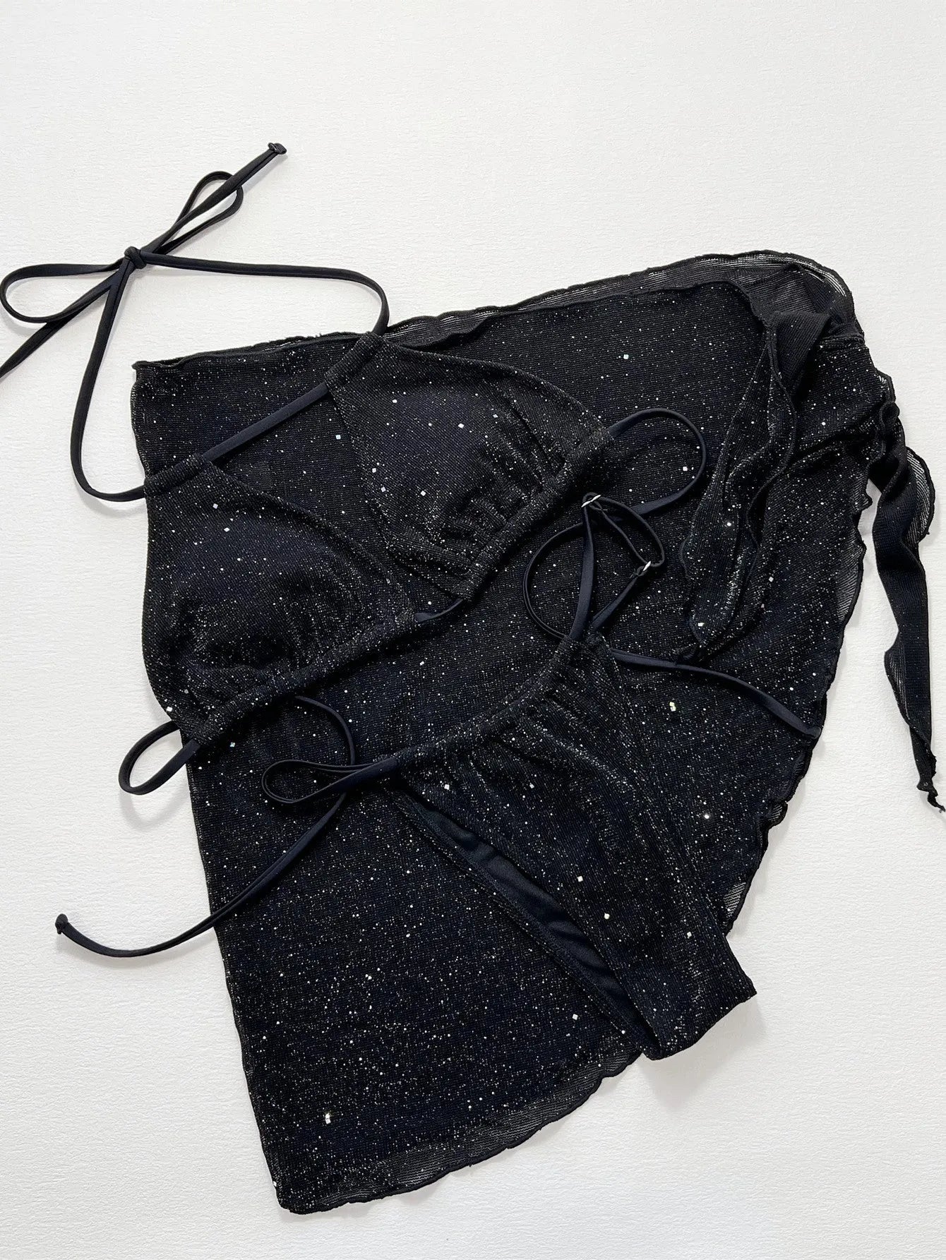 Black three-piece bikini swimsuit set with a top and shorts on a mannequin.